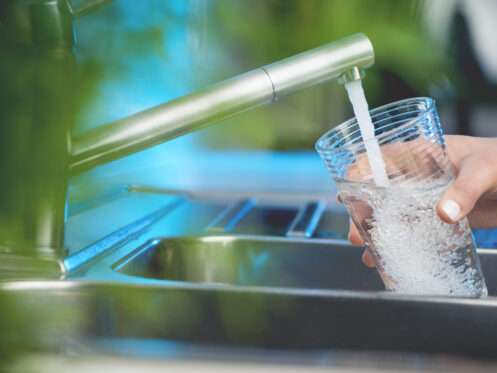 Woman filling a glass of water.